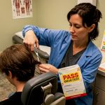 Lab technician cutting hair sample for test