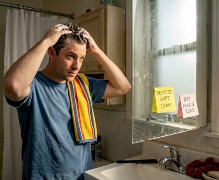 Man shampooing hair in everyday apartment bathroom