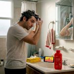 Man applying hair detox shampoo in bathroom