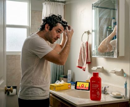 Man applying hair detox shampoo in bathroom