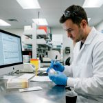 Lab technician labeling drug test sample cup