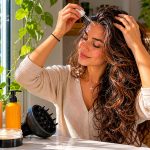 Woman applying scalp serum in bathroom