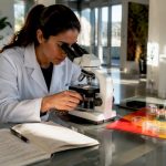 Researcher examining hair follicle sample in lab