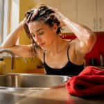Woman applying detox shampoo in bathroom