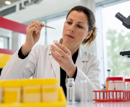 Technician extracting hair sample in forensic lab
