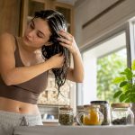 Woman applying detox shampoo in bathroom