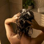 Person applying detox shampoo in bathroom