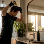 Person applying detox shampoo in bathroom