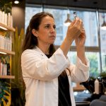 Lab technician inspecting shampoo sample in laboratory