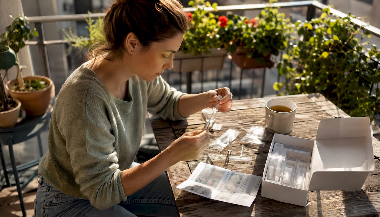 Woman assembling home hair drug test kit at table