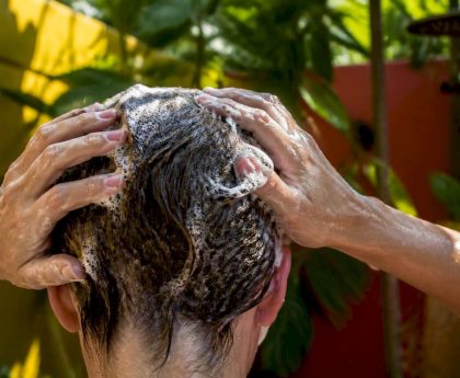 Hands applying clarifying shampoo to hair
