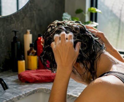 Hands applying detox shampoo to scalp