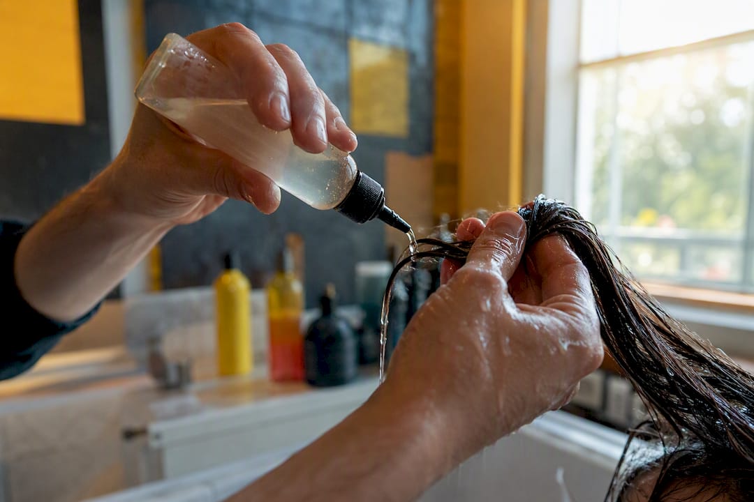 Applying acidic solution to hair strands
