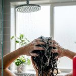 Hands rinsing hair in bathroom sink