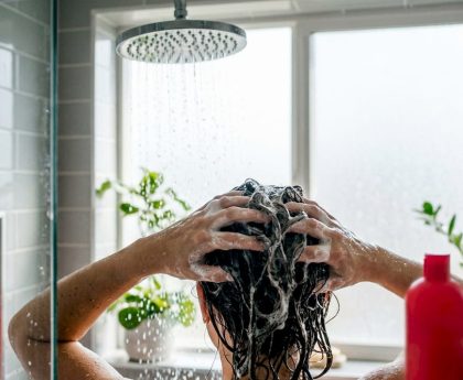 Hands rinsing hair in bathroom sink