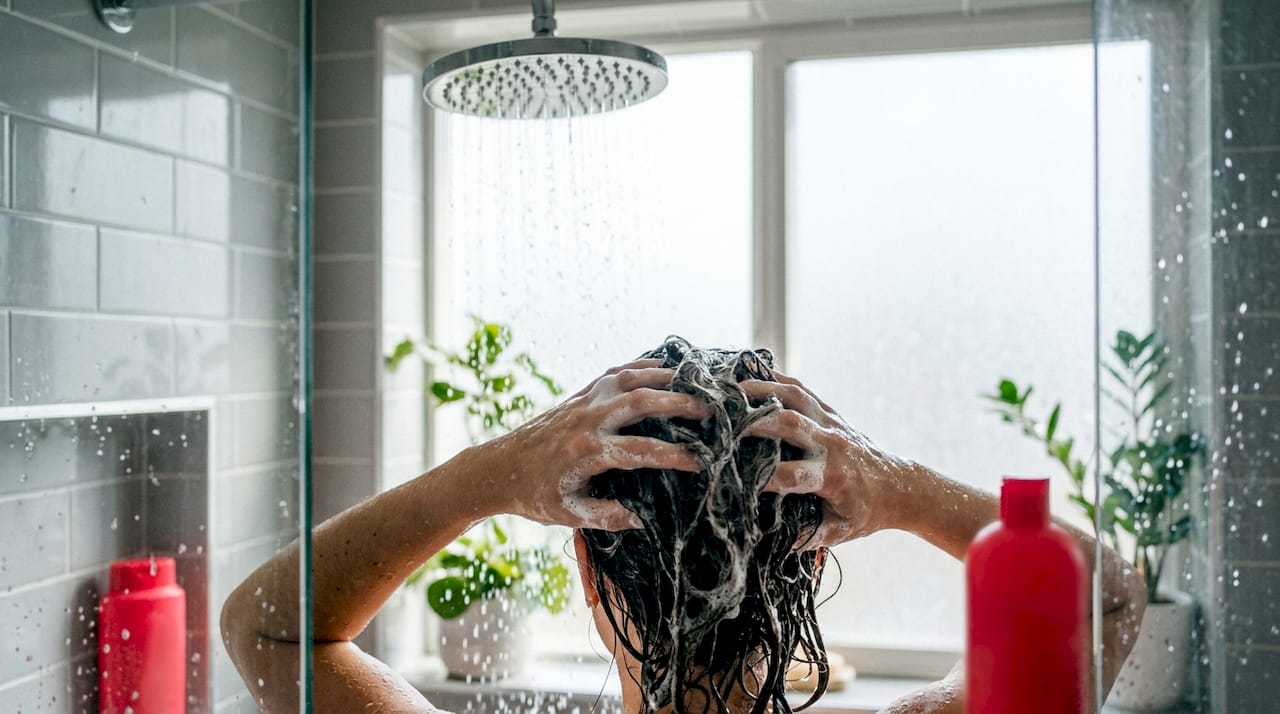 Hands rinsing hair in bathroom sink