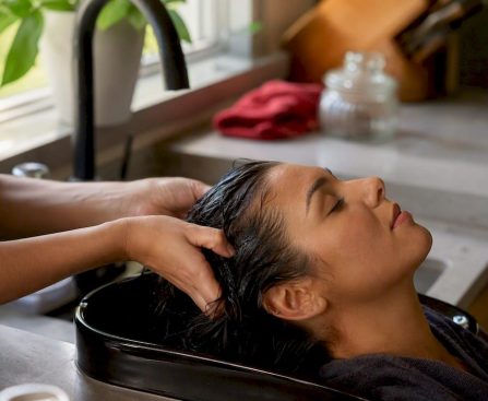 Hands washing hair near scalp at sink