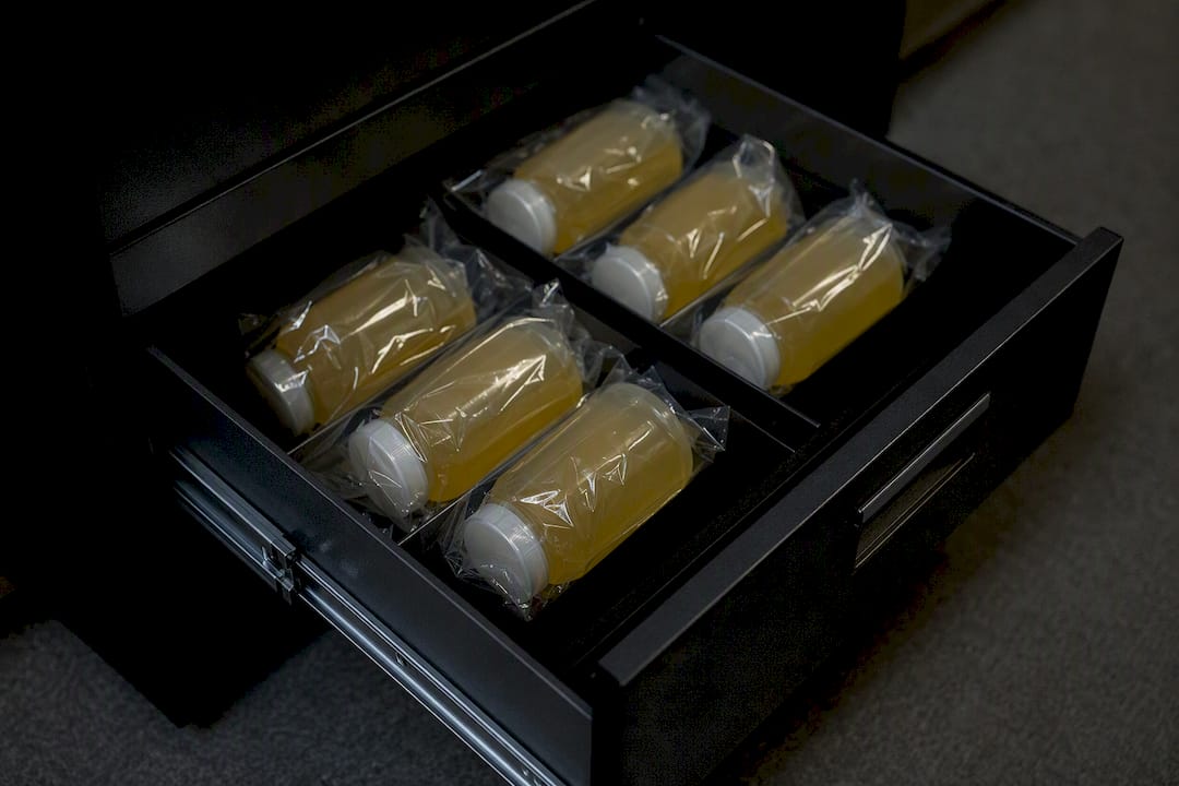 Sealed synthetic urine bottles stored in dark drawer