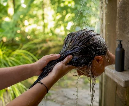Close-up of hands rinsing hair at sink
