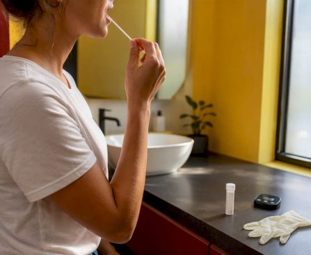 Person collecting saliva sample with swab