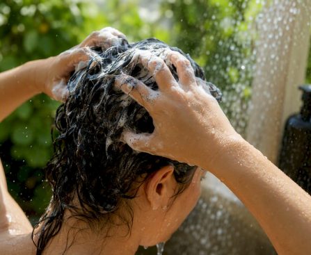 Hands applying detox shampoo to scalp