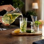 Hands mixing detox drink in kitchen