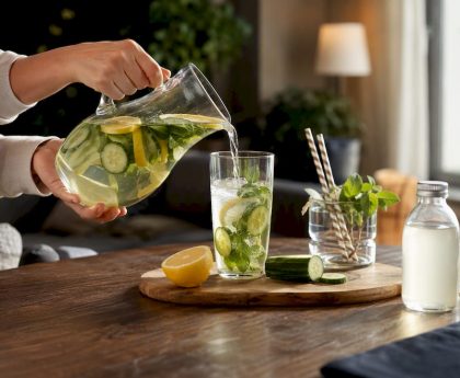 Hands mixing detox drink in kitchen