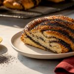 Poppy seeds beside a baked pastry