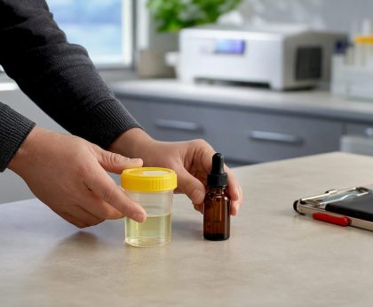 CBD bottle beside workplace test cup
