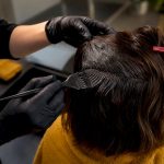 Stylist applying dye to dark hair