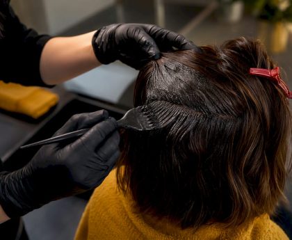 Stylist applying dye to dark hair