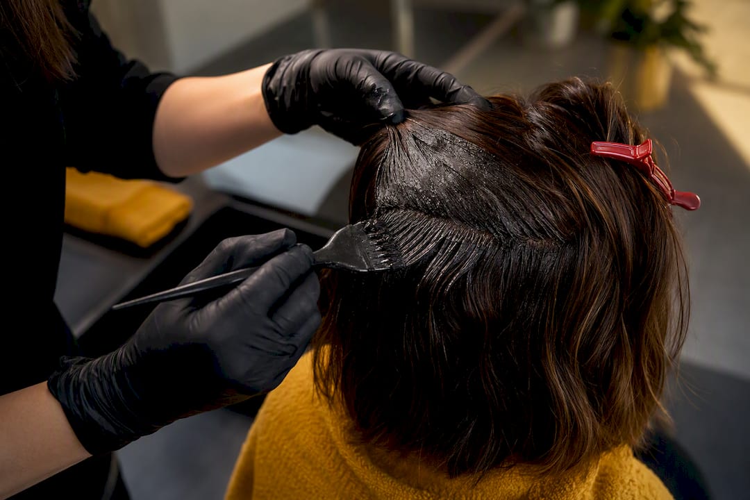 Stylist applying dye to dark hair