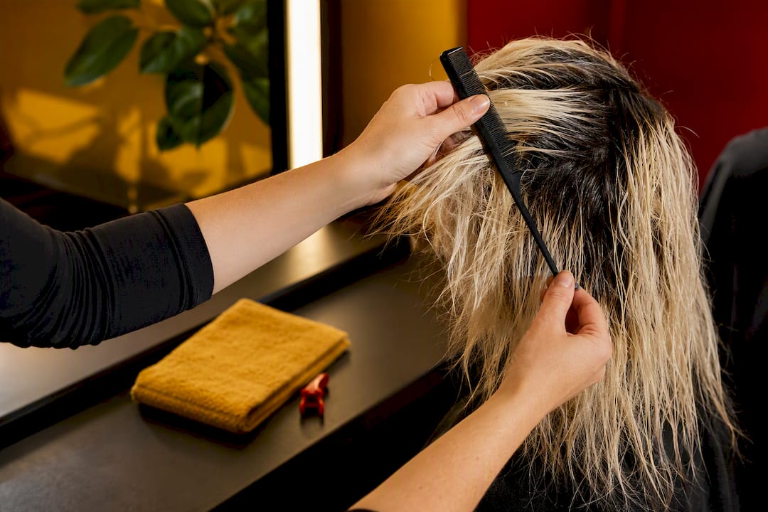 Colorist inspecting recently bleached hair