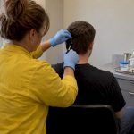 Professional collecting a hair drug test sample