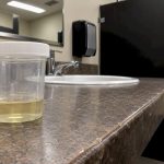 Urine specimen cup in collection restroom