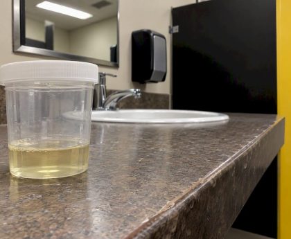 Urine specimen cup in collection restroom