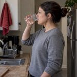 Woman drinks water before urine test
