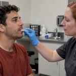 Collector taking a supervised oral fluid swab